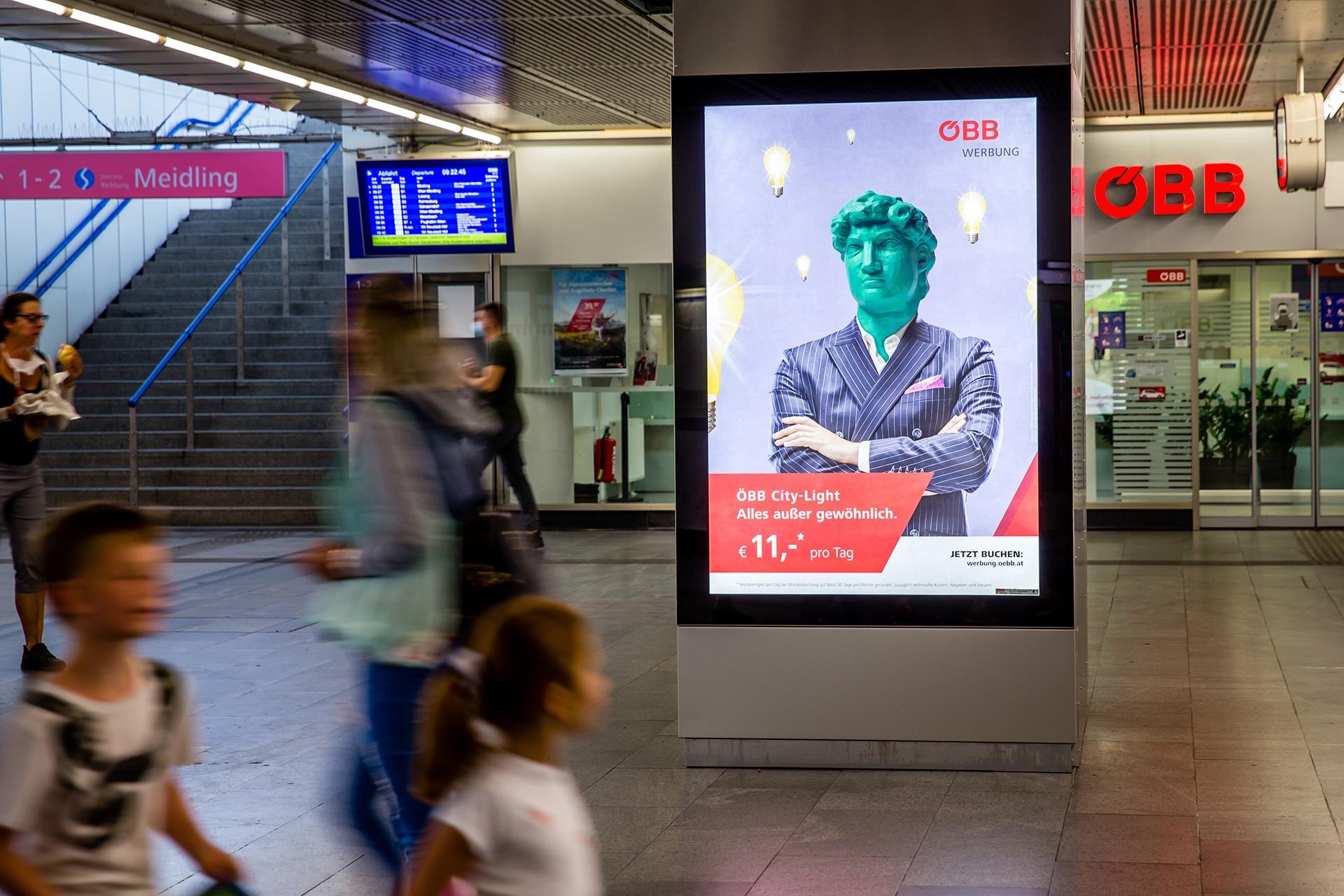 Beleuchtetes Werbeplakat am Bahnhof